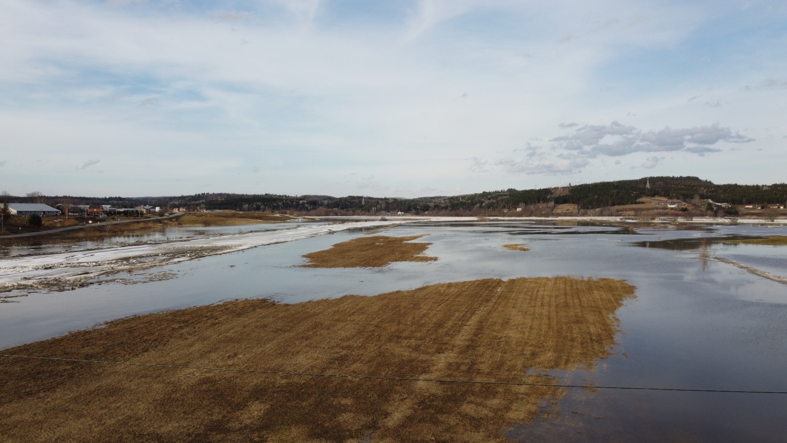 Photographie de paysage de champs inondés à la fin de l'hiver.