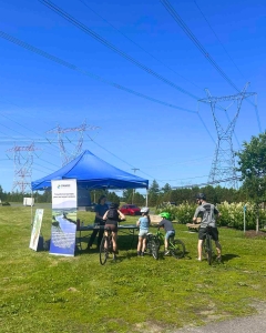 Quelques personnes s'arrêtent au kiosque du COBARIC pour découvrir l'impact de leurs actions sur les rivières et les gestes à poser, même en ville, pour protéger nos cours d'eau.